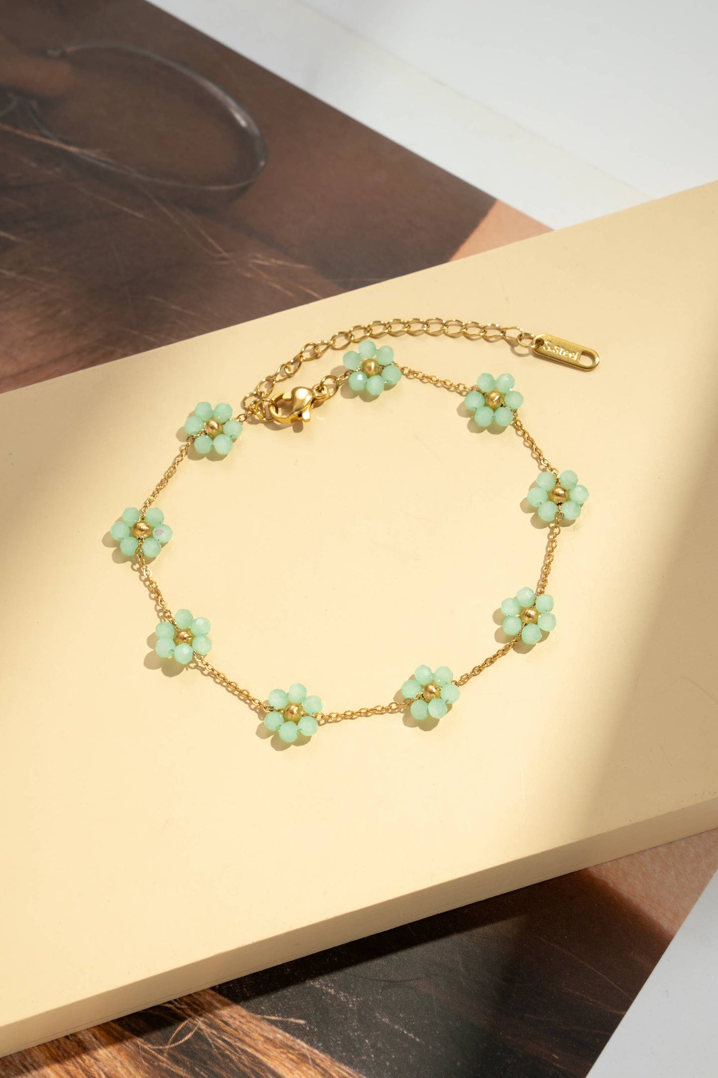 Confezione da 8 cavigliere con fiori dorati e perle colorate